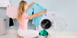 Woman Looking At Blue T-shirt In Utility Room
